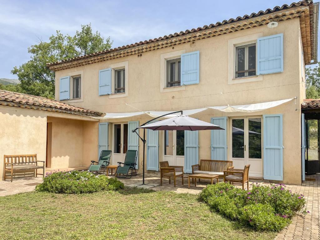 Cette maison dispose d'une terrasse avec un parasol et des chaises. dans l'établissement Mazet Pascaressa, à Tourrettes-sur-Loup