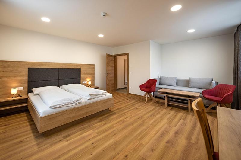 duża sypialnia z łóżkiem i kanapą w obiekcie Penker Wirt Zimmer BANK w mieście Penk