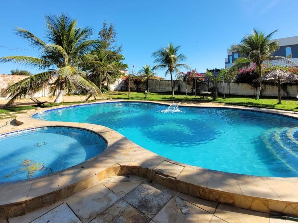 a swimming pool in a resort with palm trees at Pousada Canoa Beach in Canoa Quebrada