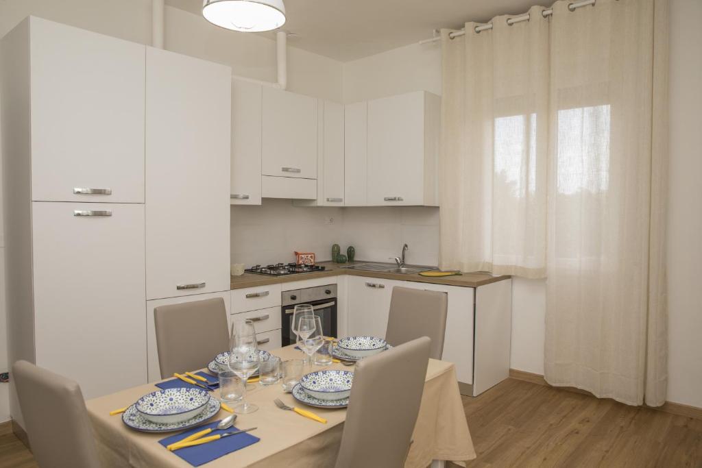 卡斯泰萊門多的住宿－La Casa dei Racconti，白色的厨房配有桌椅