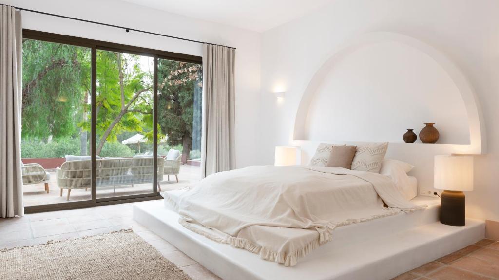 1 dormitorio blanco con 1 cama grande y ventana grande en Finca La Familia Naranja, en Coín