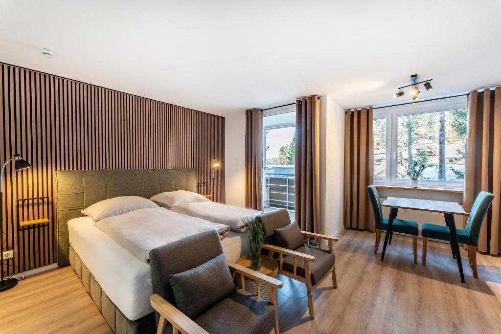 um quarto de hotel com uma cama e uma secretária em Juri5 in Baiersbronn mit Pool em Baiersbronn