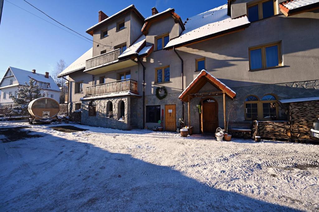 a large house with a snow covered driveway in front of it at Poza Horyzont in Korbielów