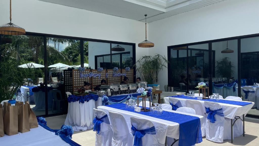 una stanza con tavoli con tovaglie blu e bianche di LA PARISIENNE PRIVÂTE BOTANICAL GARDEN RESORT 