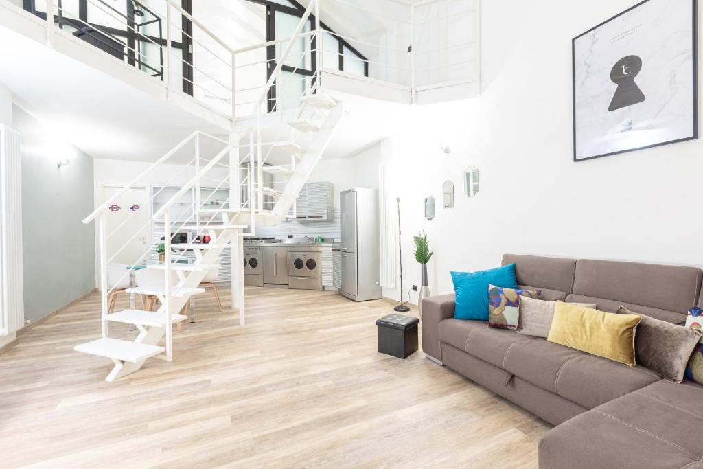 een woonkamer met een bank en een wenteltrap bij Fondazione Prada Exclusive Detached Loft - Top Collection in Milaan