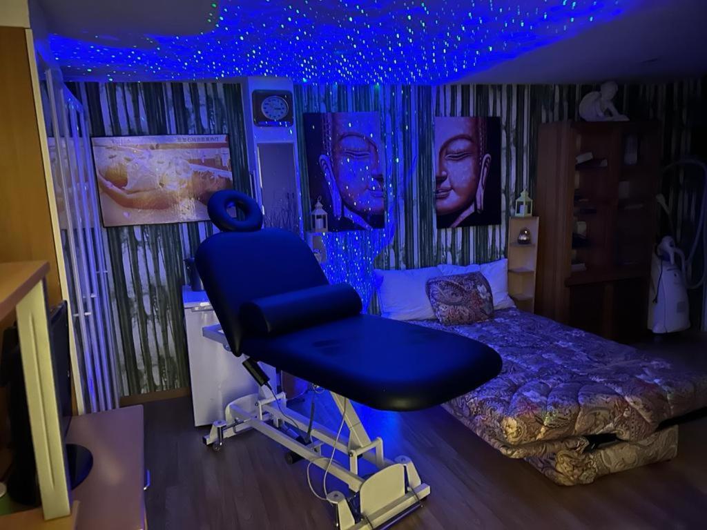 een slaapkamer met een blauwe kamer met een bed en een stoel bij Love Zen Room Atomium et Palais de l'exposition in Brussel