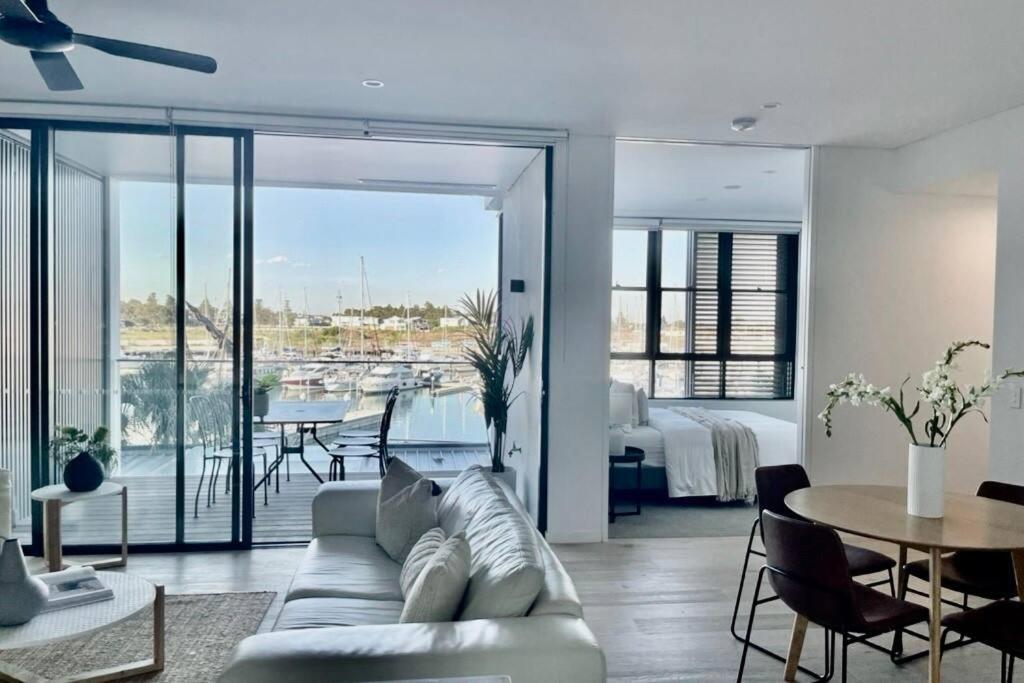 un salon avec un canapé et une table ainsi qu'une chambre dans l'établissement Luxury Apartment in Shell Cove, à Shellharbour