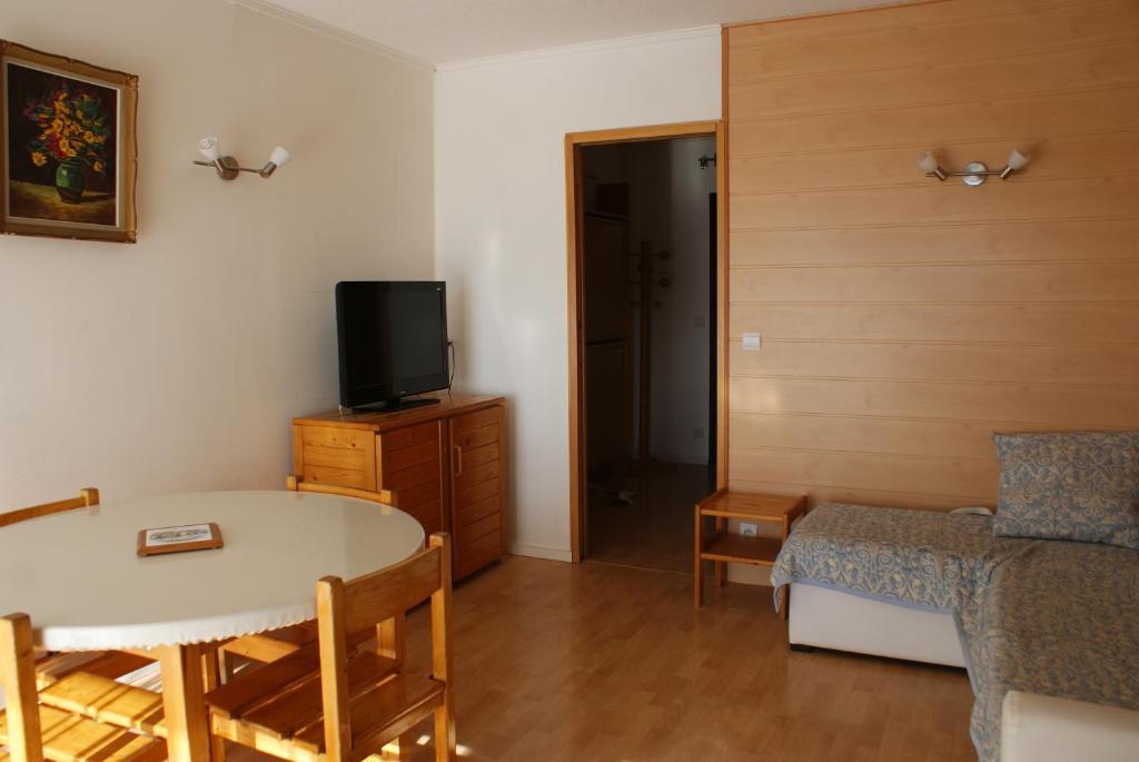 uma pequena sala de estar com uma mesa e uma televisão em ETOILE DES NEIGES em Orcières