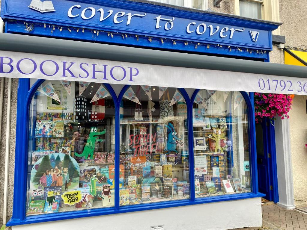 a book shop with a blue sign in the window at The Bookshelf in Oystermouth