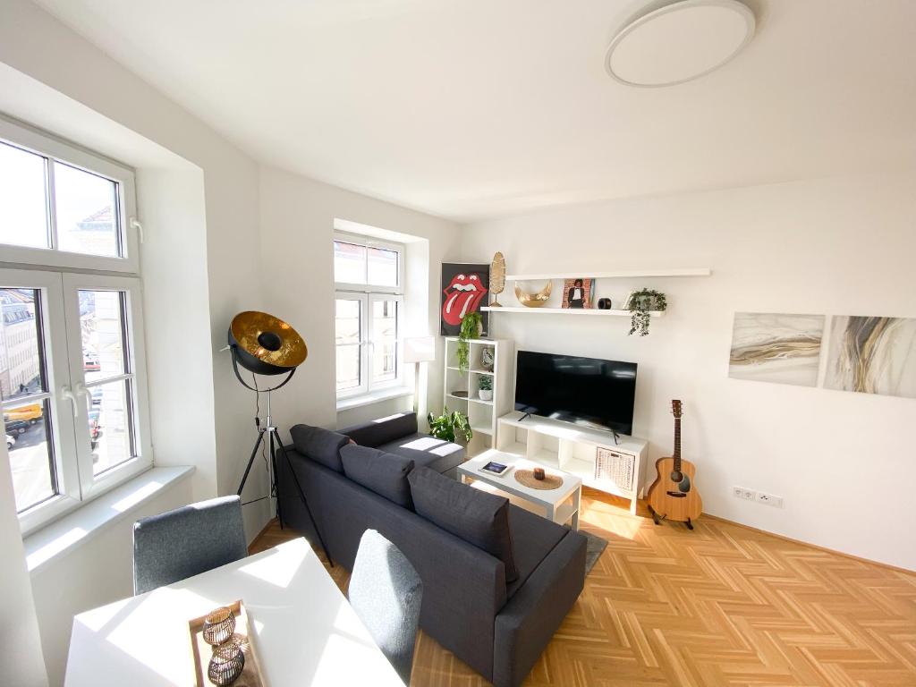 - un salon avec un canapé et une télévision dans l'établissement Central Vienna Luxury Stay w/ parkview, near metro, à Vienne