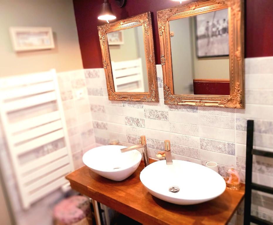 a bathroom with two sinks and two mirrors at GITE Le Relais de la Baie in Millencourt-en-Ponthieu