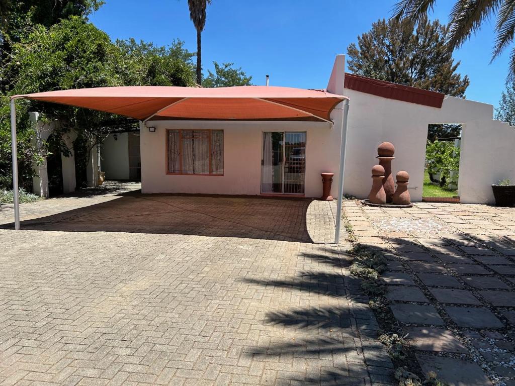 una casa con una sombrilla grande delante de ella en INTERPRO, en Bloemfontein