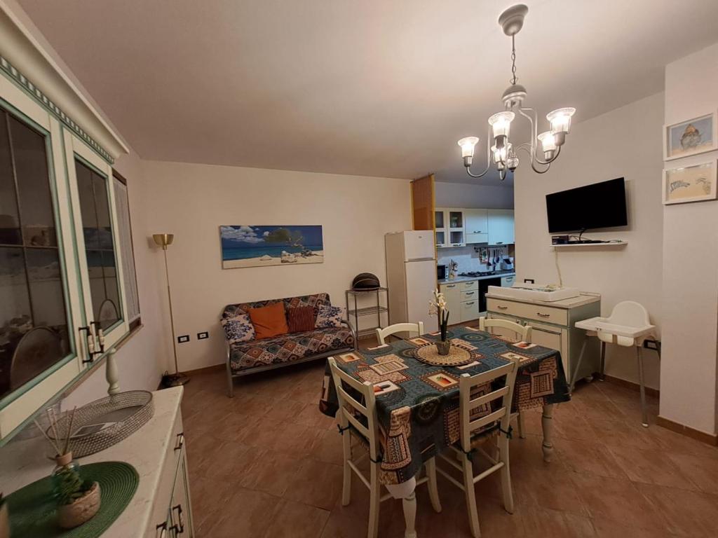 eine Küche und ein Wohnzimmer mit einem Tisch und Stühlen in der Unterkunft Casa vacanze sole e mare in Porto Pino