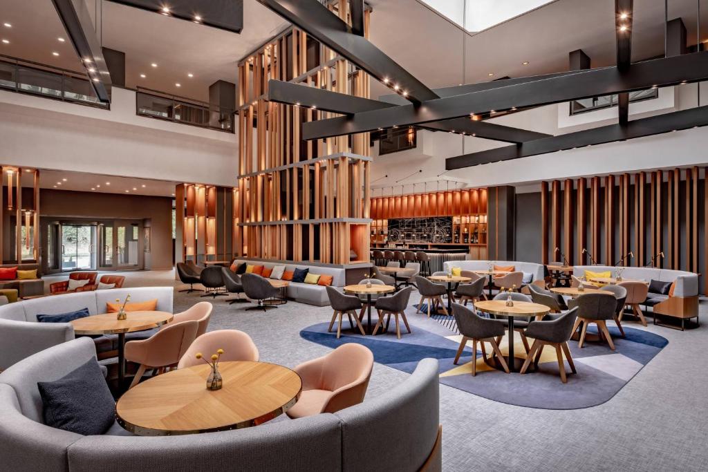 um restaurante com sofás, mesas e cadeiras em Stuttgart Marriott Hotel Sindelfingen em Sindelfingen