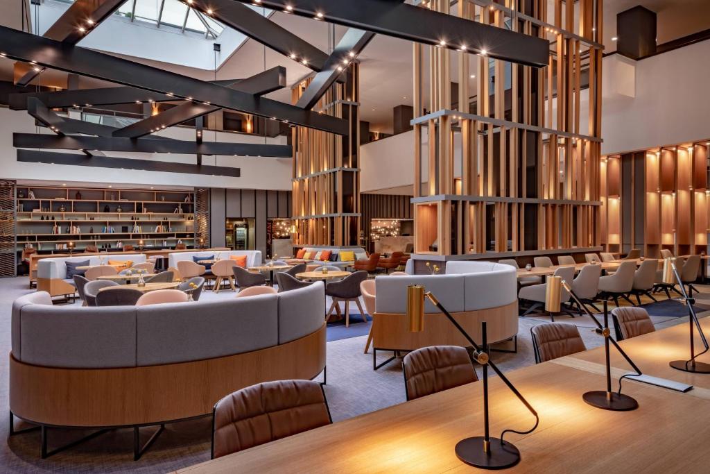 a lobby with a library with couches and chairs at Stuttgart Marriott Hotel Sindelfingen in Sindelfingen