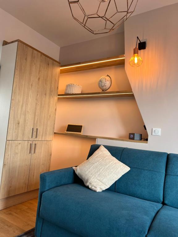 a living room with a blue couch and a cabinet at Rooms with fabulous view on Paris roofs in Paris