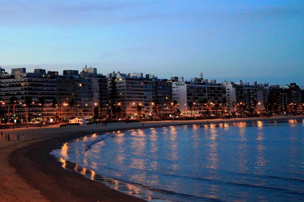 vistas a una playa por la noche con edificios en ALCA Apartamento exclusivo a 80 mts de Playa Pocitos, en Montevideo