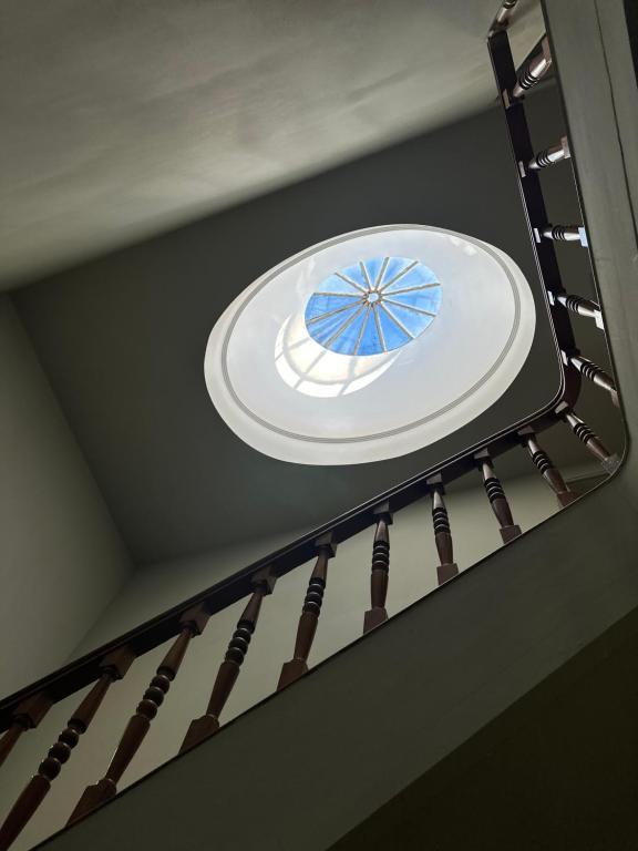 a white plate on a staircase with a window at A Beira Hostel in Aveiro