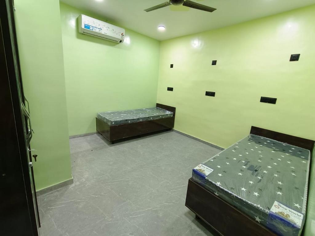 a room with two beds and a ceiling fan at Agrawal Stay Viman Nagar (Female Only) in Pune