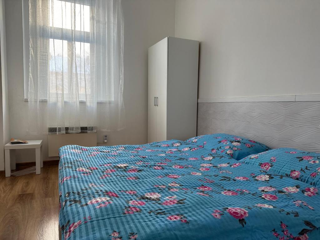 a bedroom with a bed with a blue comforter at Penzion Sokolov in Sokolov