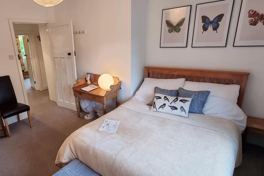 a bedroom with a bed and a desk with a lamp at The Flat at Conway House in Overstrand