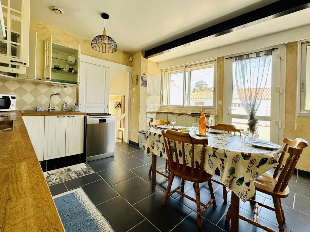 une cuisine avec une table et des chaises dans l'établissement Maison de vacances au calme quartier de la Chaume 5 pers, à Les Sables-dʼOlonne