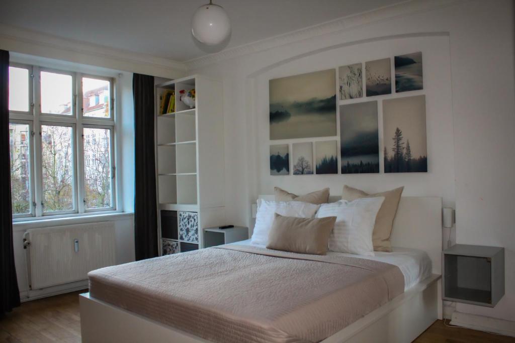 a white bedroom with a large bed and a window at Centrally Located 4 Room Apartment in Copenhagen