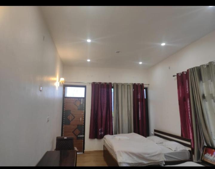 een slaapkamer met een bed en een raam met gordijnen bij G Homestay in Munsyari