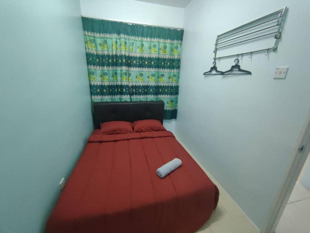 ein rotes Bett in einem Zimmer mit Rollen darauf in der Unterkunft FZHomestays In CH in Cameron Highlands