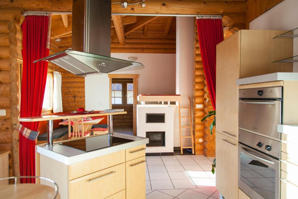 uma cozinha com cortinas vermelhas numa casa de madeira em Apartment Luxus em Ried im Oberinntal