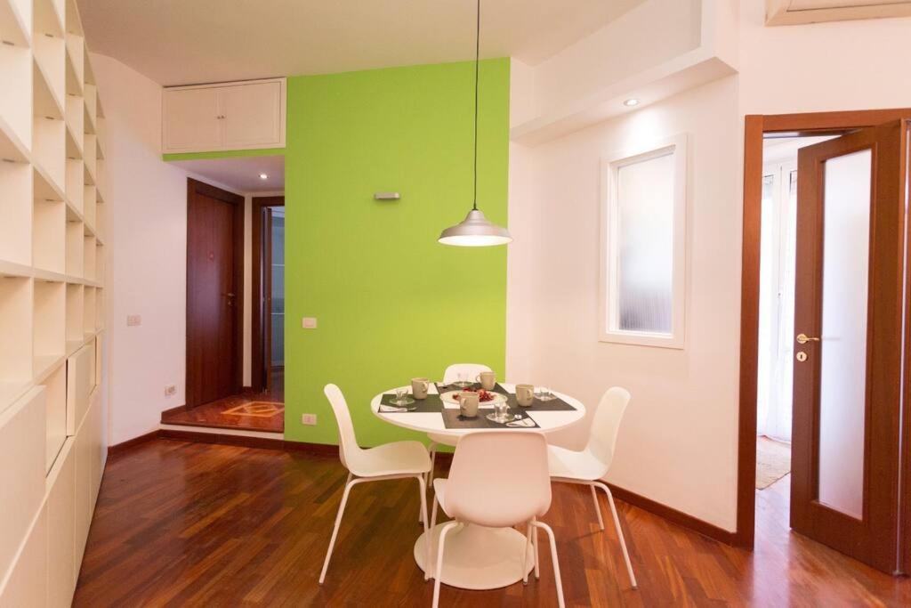 Hotel Podesti House - Flaminio Stadio Olimpico, a dining room with a green wall and a table and chairs at Podesti House - Flaminio Stadio Olimpico in Rome