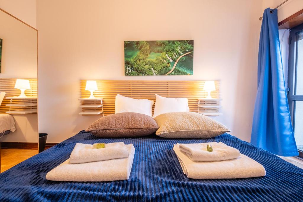1 dormitorio con 1 cama azul y 2 toallas en Celas Dream Studio, en Coímbra