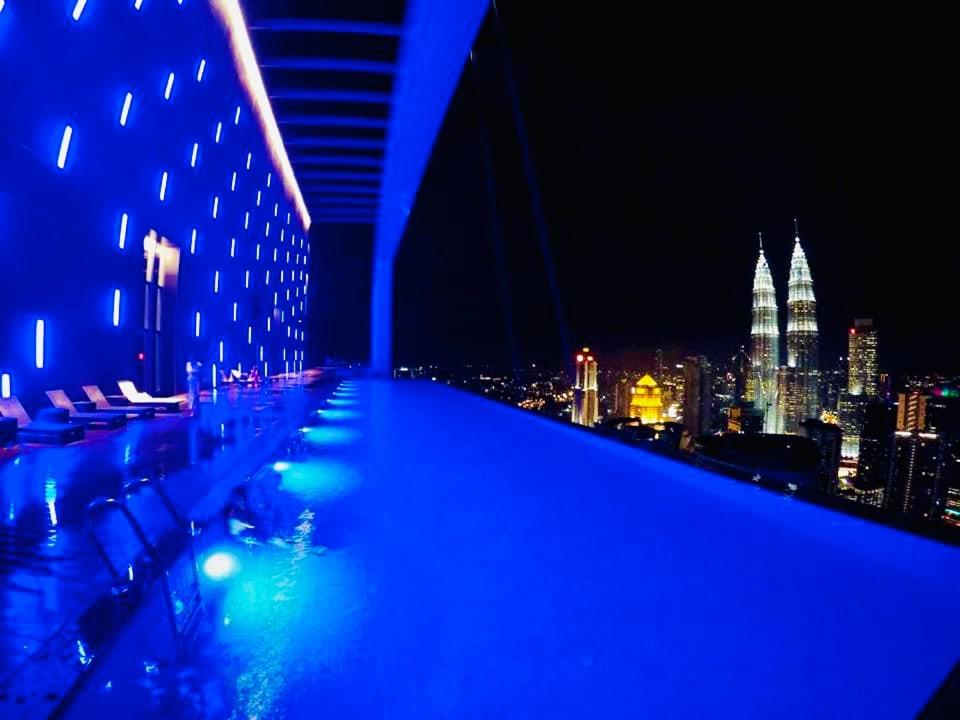 a rooftop bar with a view of the city at night at amazing suites at platinum suites in Kuala Lumpur