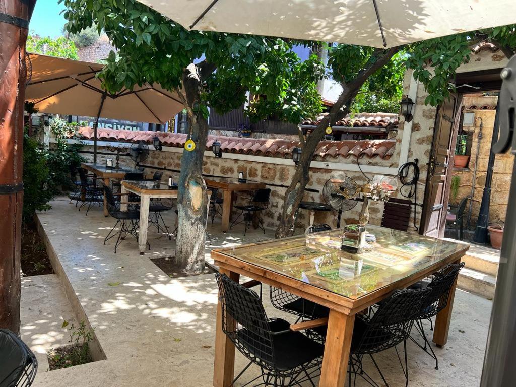 una mesa y sillas bajo una sombrilla en un patio en Villa Citronella Boutique Hotel, en Antalya