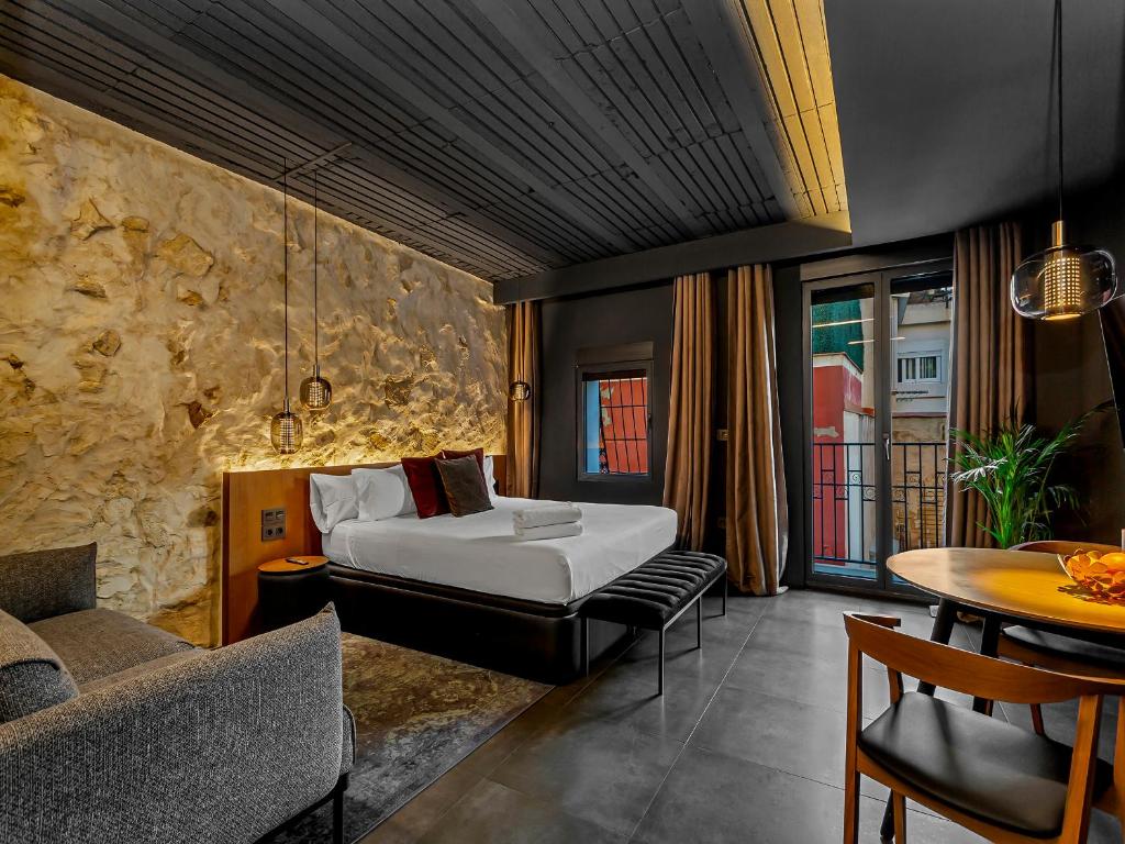 ein Hotelzimmer mit einem Bett und einem Tisch in der Unterkunft Apartaestudios Evolution Luxury in Alicante