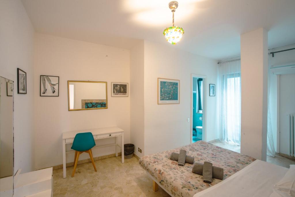 a bedroom with two beds and a desk and a chair at Guest House Ca' Lou al Teatro in Vicenza
