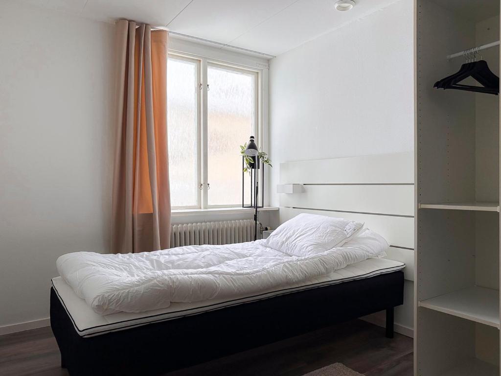 Bett in einem Zimmer mit Fenster in der Unterkunft Rosen in Nässjö