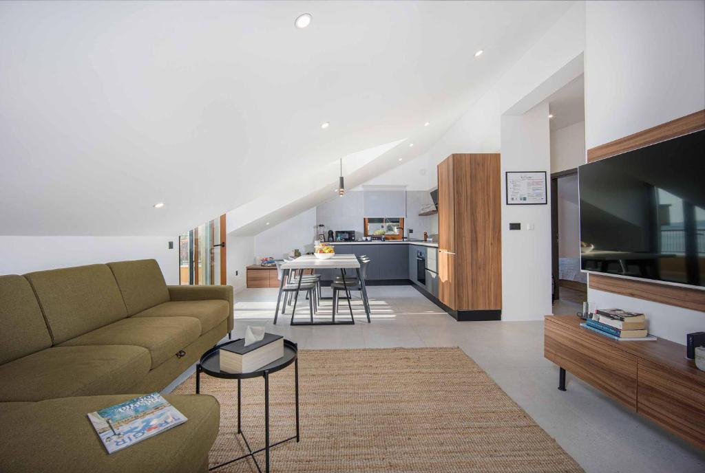 un soggiorno con divano e TV e una cucina di Oleander Urban Suites, high-speed internet, beach at 250, PET friendly a Trogir