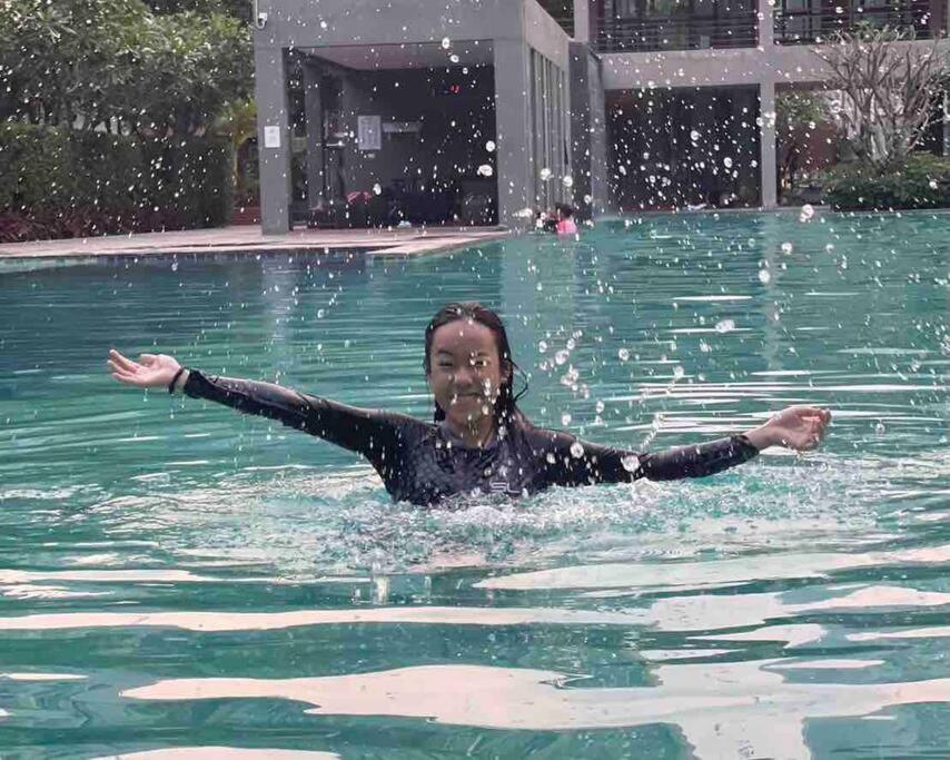 a woman swimming in a pool in the water at D condo sign D3 in Chiang Mai