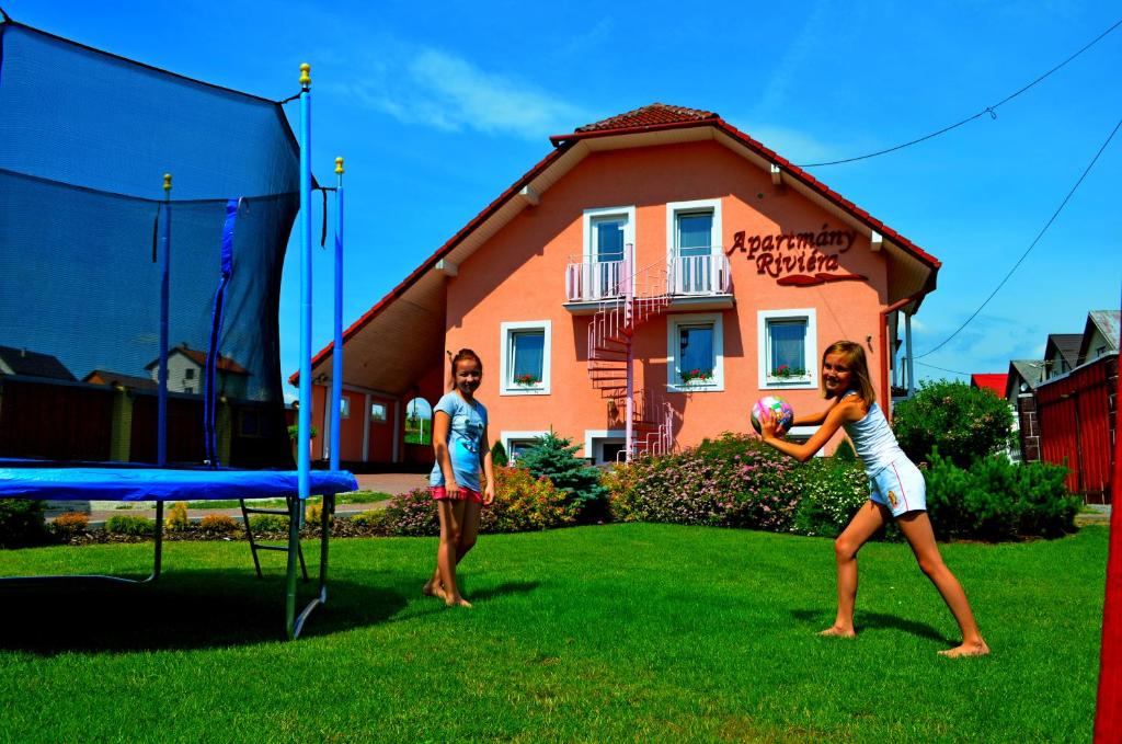 Ein Mann und eine Frau spielen ein Frisbeespiel in der Unterkunft Vila Deluxe & Apartmány Riviéra Liptov Bešeňová in Bešeňová