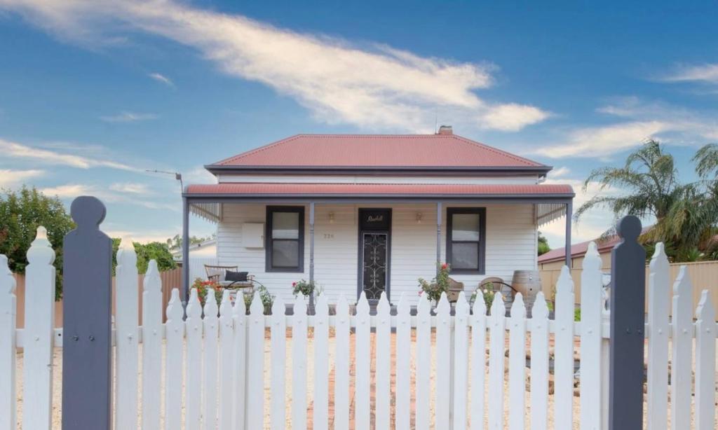a white picket fence in front of a white house at Charming 3 bedroom wine country cottage in Rutherglen