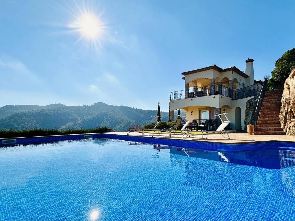 a large swimming pool in front of a house at Aurea CostaBravaSi in Sant Feliu de Guíxols