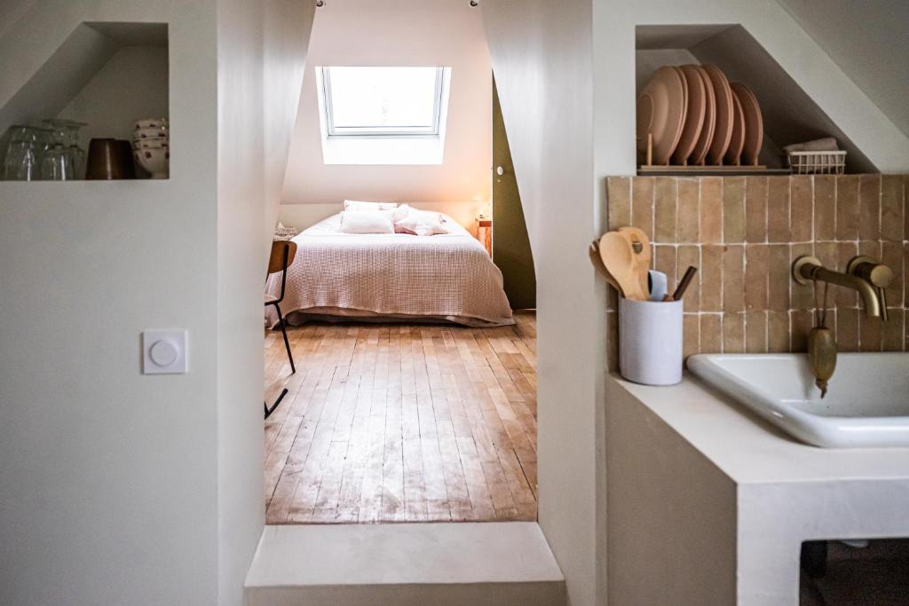 een badkamer met een bed en een wastafel in een kamer bij l'escapade à deux pas de Lille 
