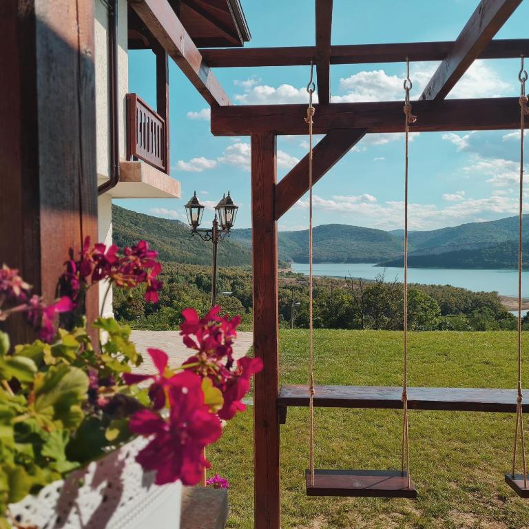 a porch with flowers and a view of a lake at Eco Lodge St Ignatius Еко лодж Игнажден in Debelets