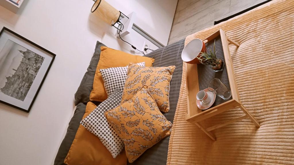 uma cama com almofadas num quarto em Dolce Vita Millau em Millau