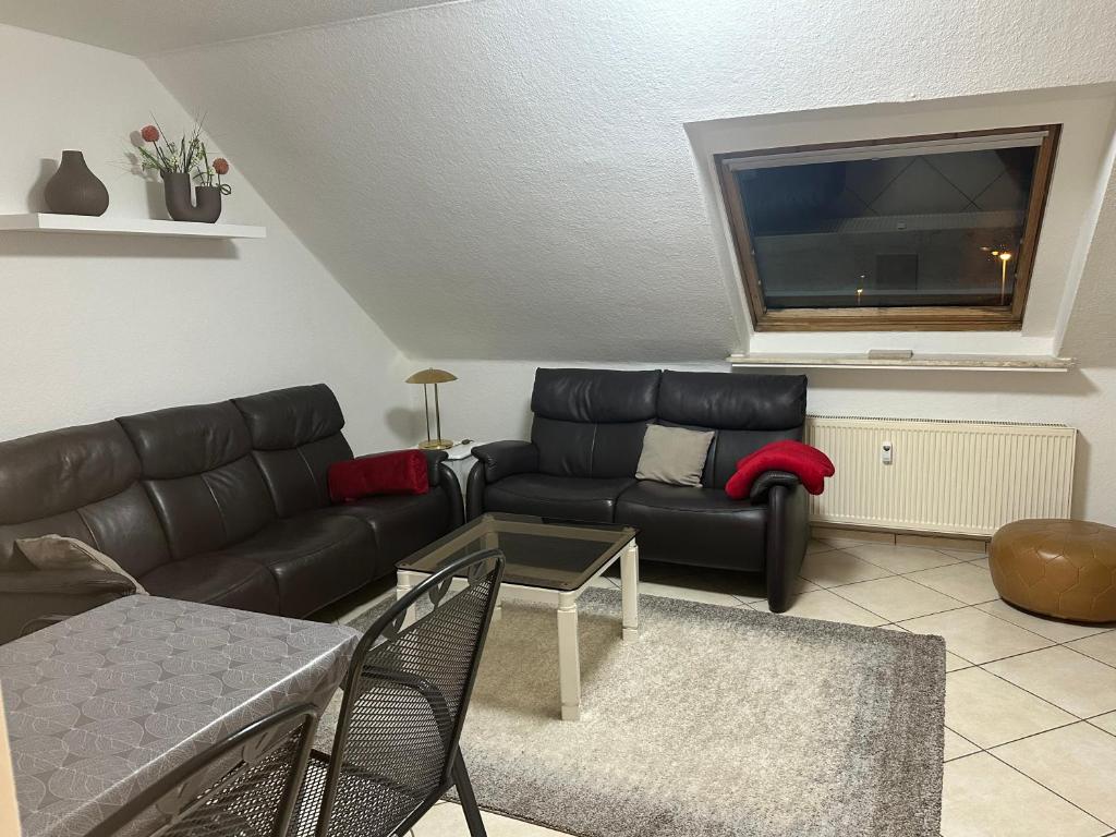 a living room with a black couch and a tv at Aminas Ferienwohnung Bad Gandersheim 30/2 in Bad Gandersheim