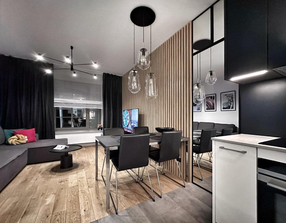 a kitchen and living room with a table and chairs at IDYLLA Apartamenty w sercu Wrocławia na Ostrowie Tumskim in Wrocław