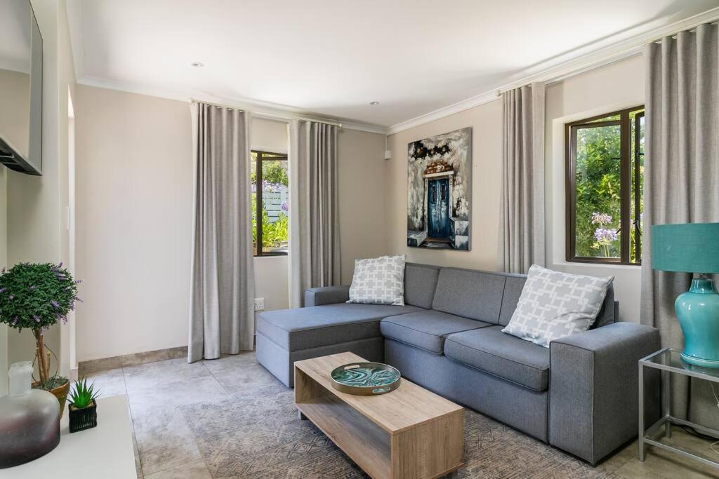 a living room with a couch and a coffee table at Modern 1 bedroom non-seafacing unit on luxury golf estate in Knysna