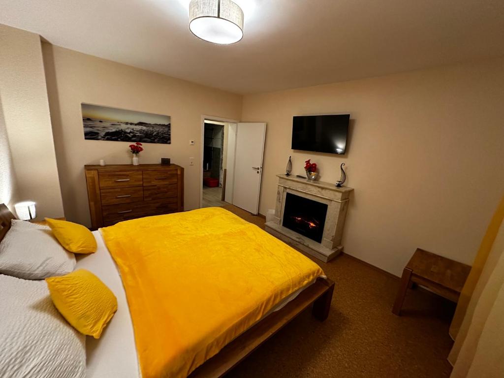 een slaapkamer met een bed met gele lakens en een open haard bij CATS Home in Bottrop