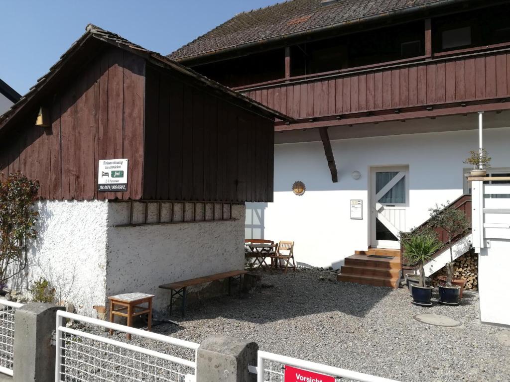 a white building with a wooden roof and a bench at Stricker in Markelfingen